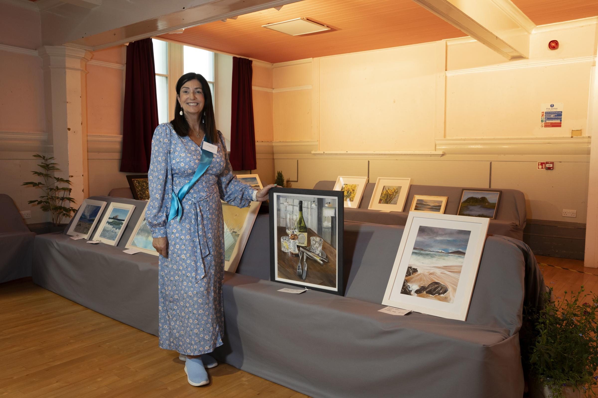 Catherine Page with her still life and landscape paintings