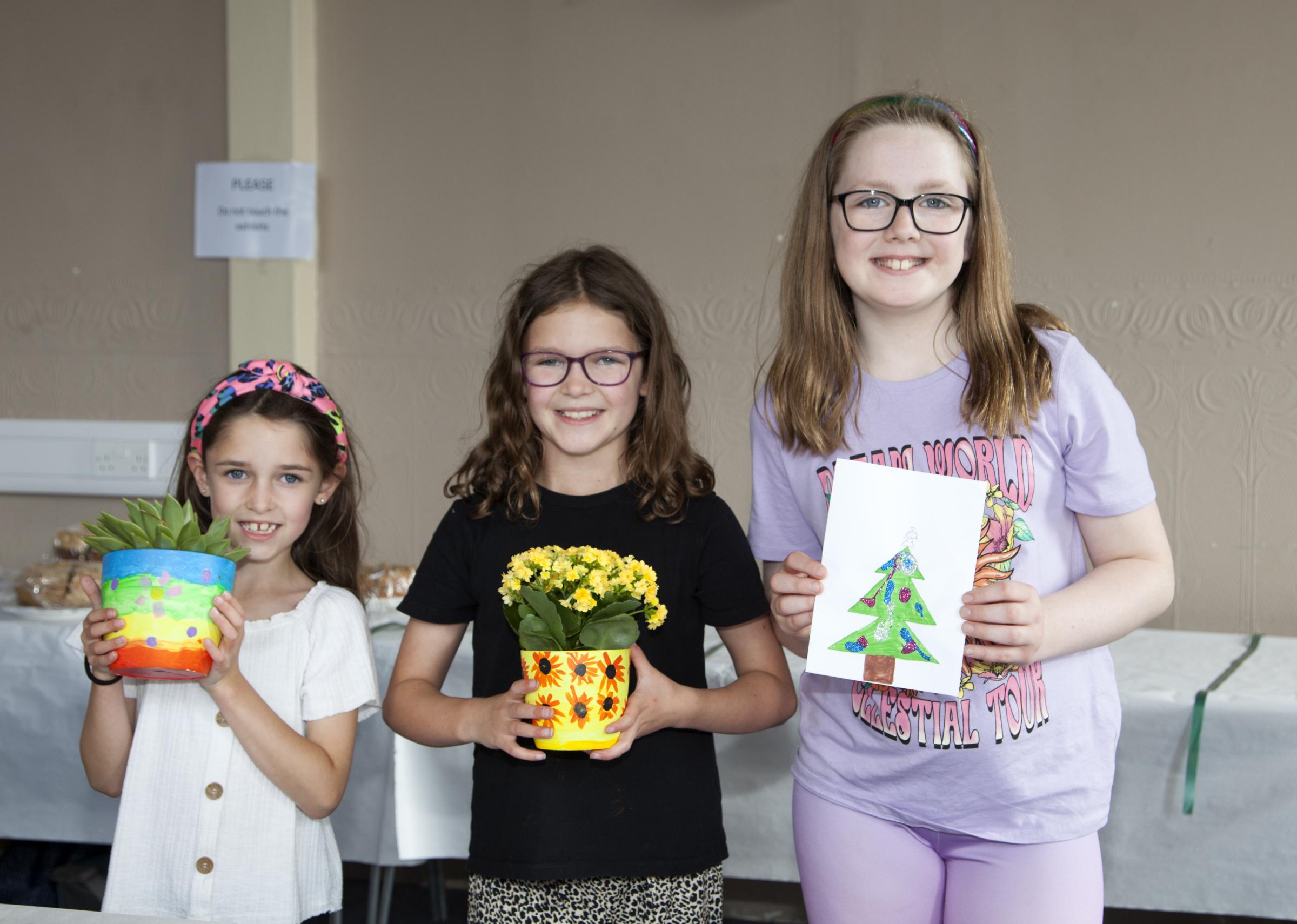 Kate and Hannah Moore and Emily Oliver who won in several catagories including sunflower, Xmas card, cookies, wrist warmer, plant in a pot, vegetable animal, leaf collage.