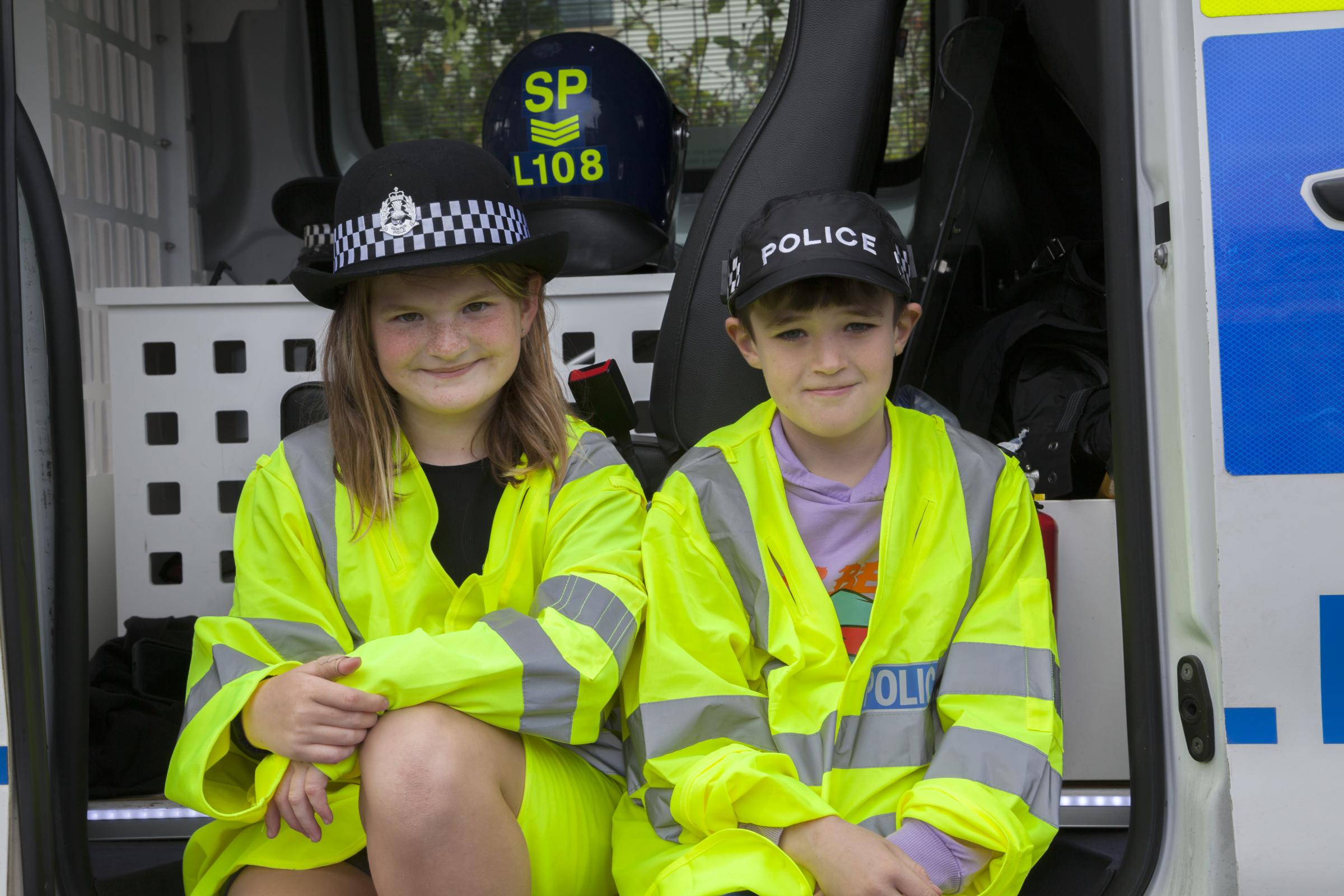 Alisha Clifton and Lucas Harvey with police jackets and hats.